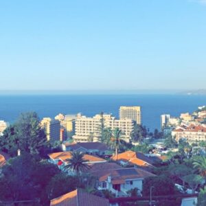 Uitzicht op stad en zee vanaf heuveltop.