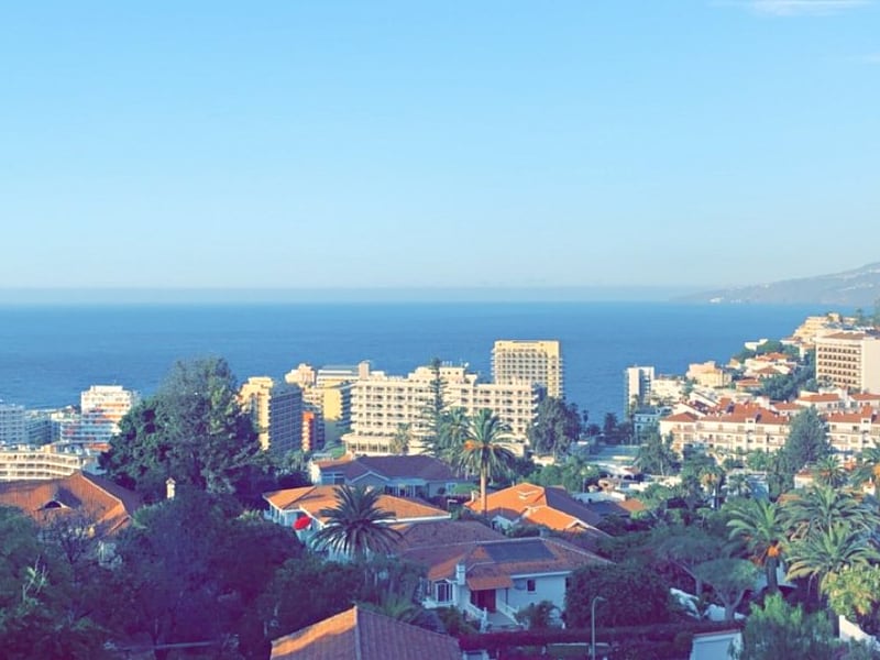 Uitzicht op stad en zee vanaf heuveltop.