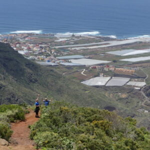 Wandelaars op heuvel met uitzicht op zee.