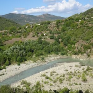 Rivier door bergachtig landschap met groene heuvels.