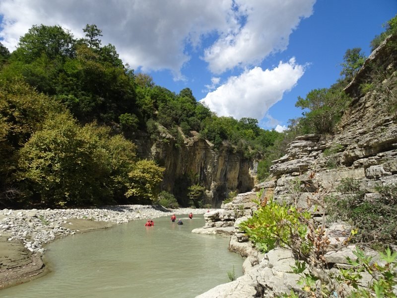 Klif, rivier en mensen in rode kajaks