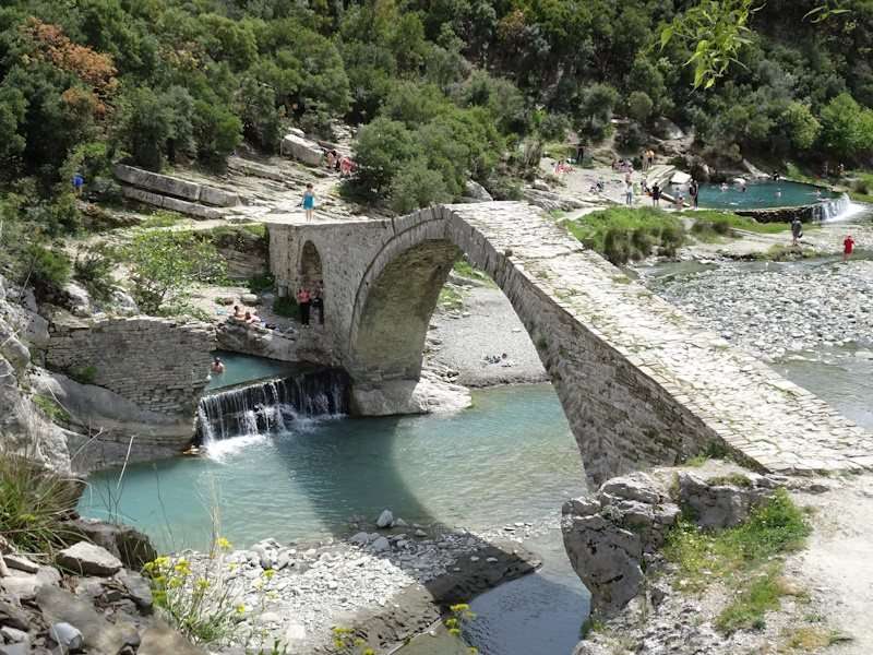 Oude stenen brug over water met omliggende natuur