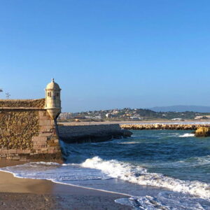 Kustlijn met oud fort en golven in de zee.