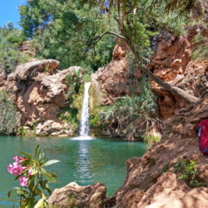 Prachtige waterval met groene omgeving en rugtas.