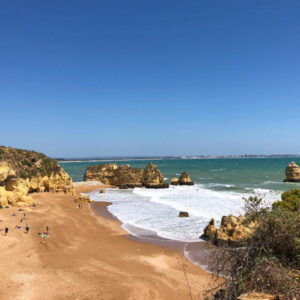 Strand met rotsformaties en blauwe hemel in Portugal.