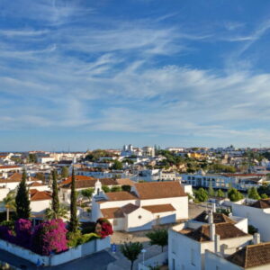 Panorama van stad met witte gebouwen en blauwe lucht.