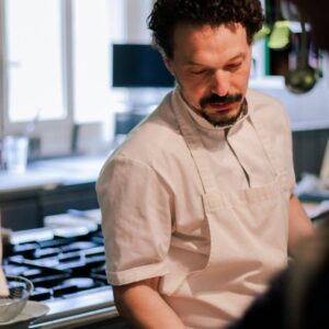 Kok werkt in keuken met kookgerei.