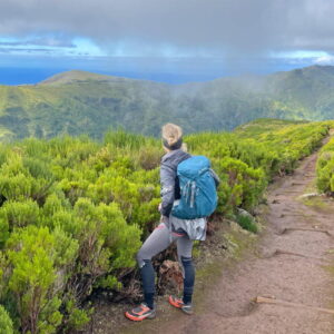 Wandelaar geniet van berguitzicht en groene natuur.