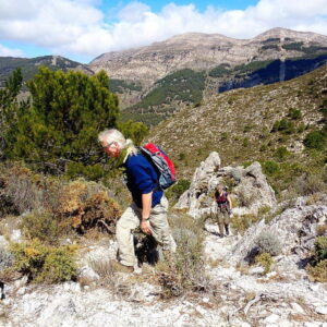 Wandelaars in bergachtig landschap op zonnige dag.