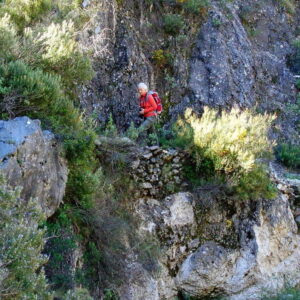 Wandelaar op rotsachtig pad in de bergen.