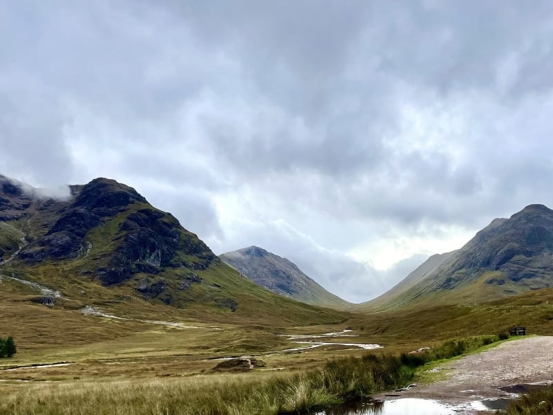 Hoge bergen onder bewolkte lucht in vallei.