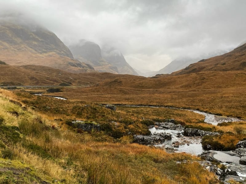 Berglandschap met beek onder bewolkte hemel