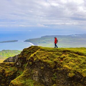 Wandelaar op heuvel met uitzicht op zee
