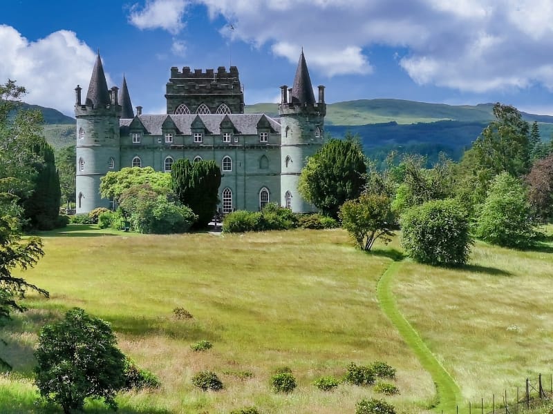Kasteel met torens omringd door groen landschap.