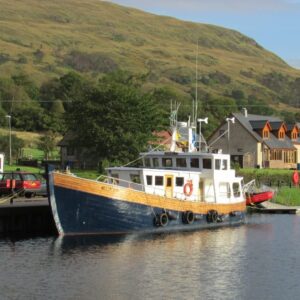 Schip aangemeerd bij kanaal in landelijke omgeving.