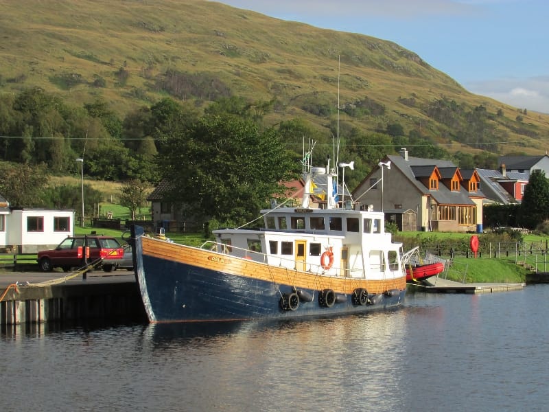 Schip aangemeerd bij kanaal in landelijke omgeving.