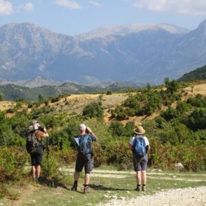 Wandelaars kijken naar berglandschap met verrekijkers.